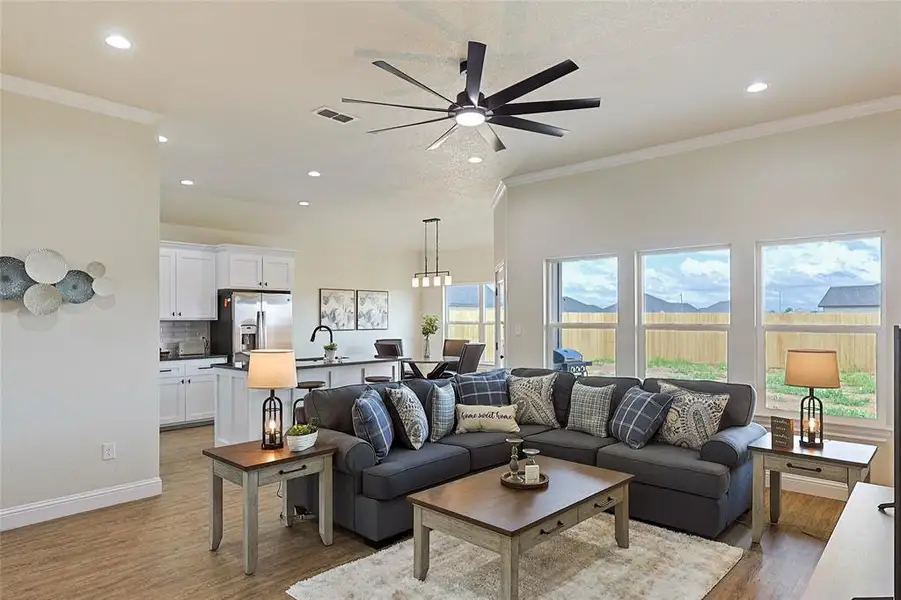 Open-concept living area with vaulted ceilings and wood-finish flooring Open-concept living area with vaulted ceilings and wood-finish flooring