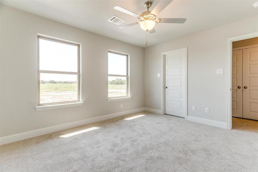 Unfurnished room featuring light colored carpet and ceiling fan