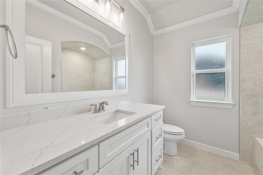 Full bath featuring vanity, ornamental molding, and light tile patterned flooring Full bath featuring vanity, ornamental molding, and light tile patterned flooring