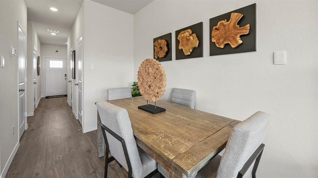 Dining area with dark wood-style floors and recessed lighting