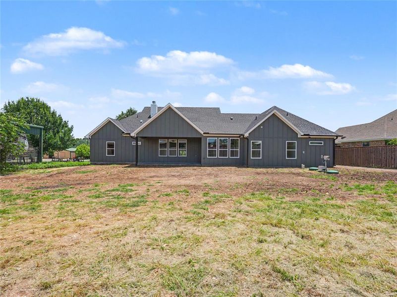Contemporary ranch-style home featuring gray vertical siding and white trim accents Contemporary ranch-style home featuring gray vertical siding and white trim accents