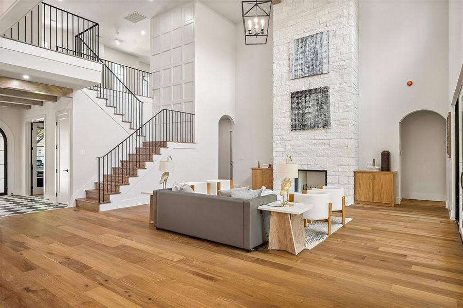 Two-story living room, floor-to-ceiling stone fireplace, iron stair railing, wide plank hardwood floors Two-story living room, floor-to-ceiling stone fireplace, iron stair railing, wide plank hardwood floors