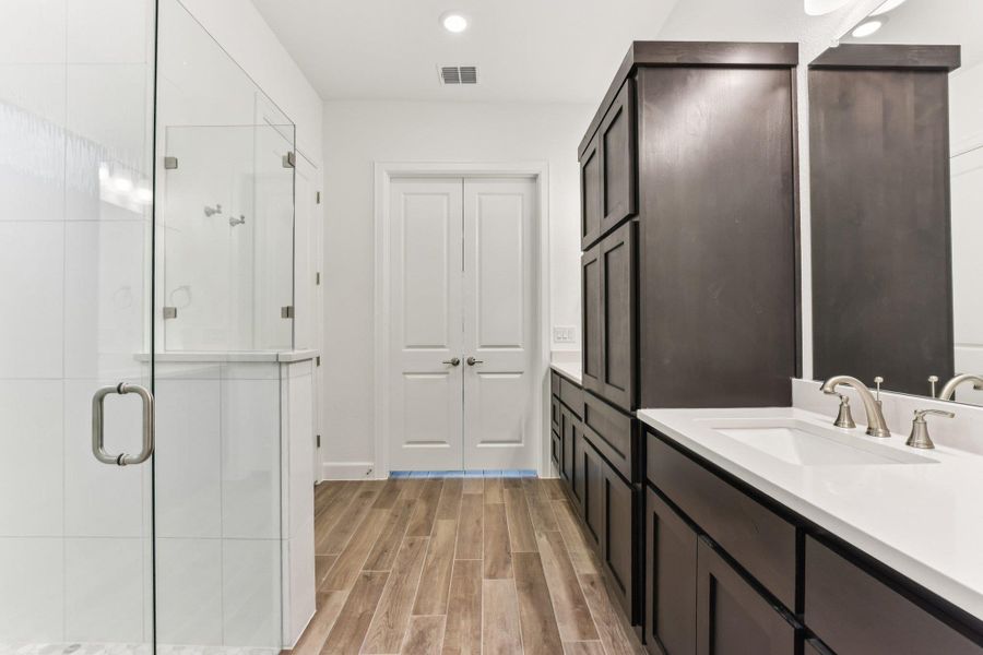 Full bath with wood finish floors, vanity, a shower stall, and recessed lighting Full bath with wood finish floors, vanity, a shower stall, and recessed lighting