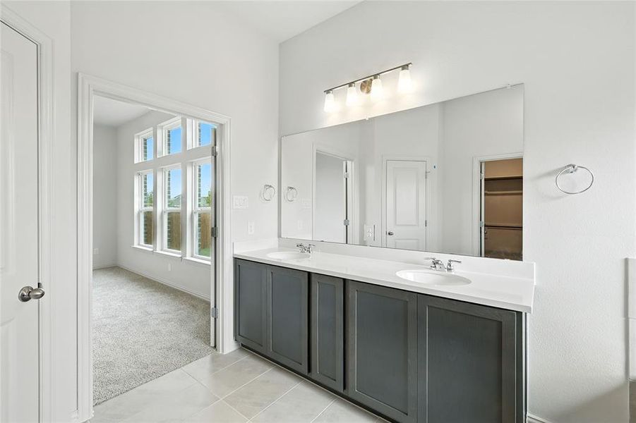 Bathroom featuring double vanity and light tile patterned flooring Bathroom featuring double vanity and light tile patterned flooring