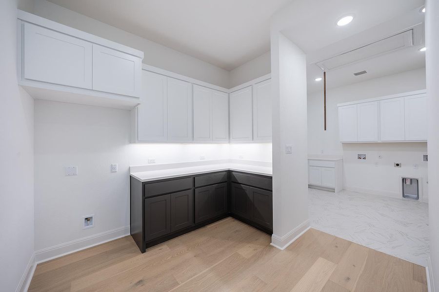 Flex room/ hobby/reading/homework area with cabinets, wood finished floors, cabinet space, and recessed lighting