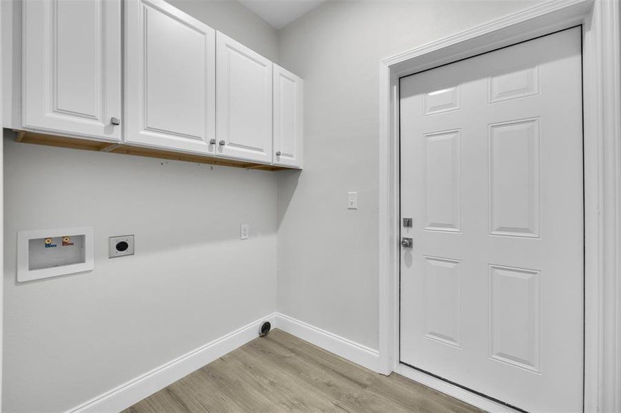 Laundry room with hookup for a washing machine, light wood-style flooring, hookup for an electric dryer, baseboards, and cabinet space Laundry room with hookup for a washing machine, light wood-style flooring, hookup for an electric dryer, baseboards, and cabinet space