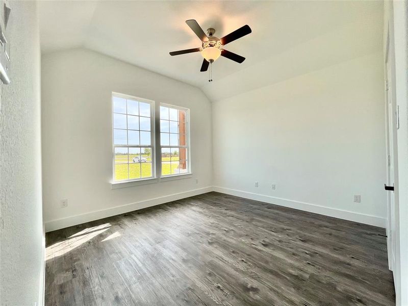 Spare room featuring lofted ceiling, baseboards, ceiling fan, and dark wood finished floors Spare room featuring lofted ceiling, baseboards, ceiling fan, and dark wood finished floors