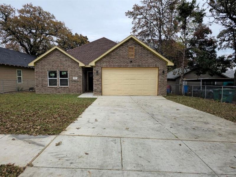 View of front of property featuring a front yard and a garage