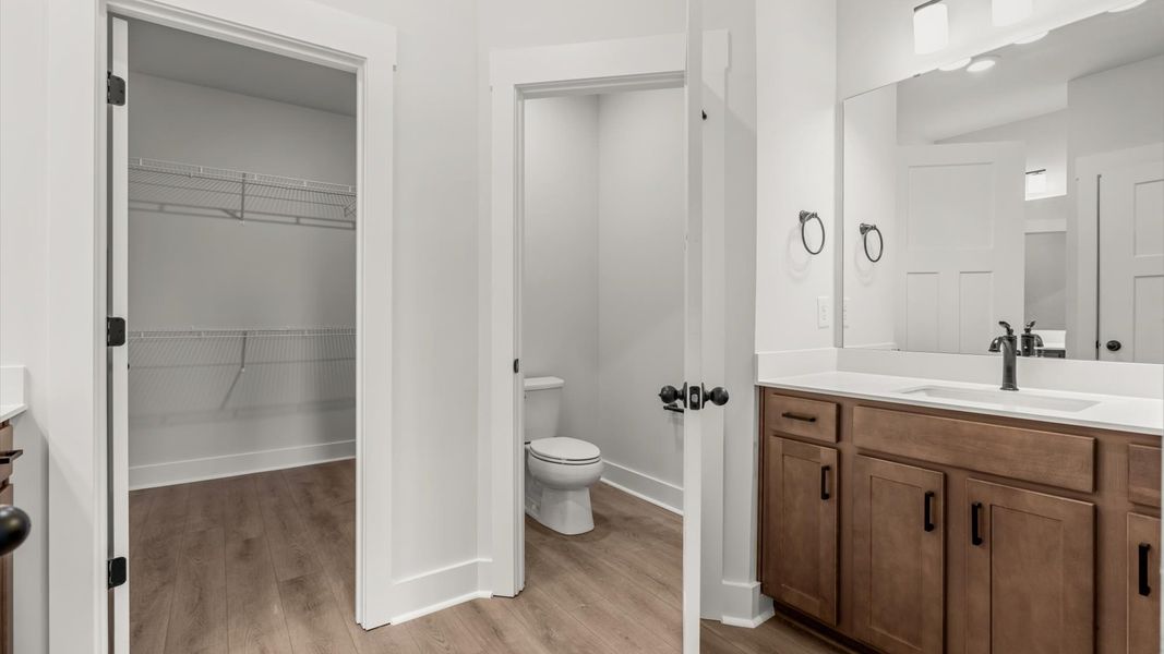 Highly functional and elegant en-suite with separate vanities, tiled walk-in shower, and refined finishes