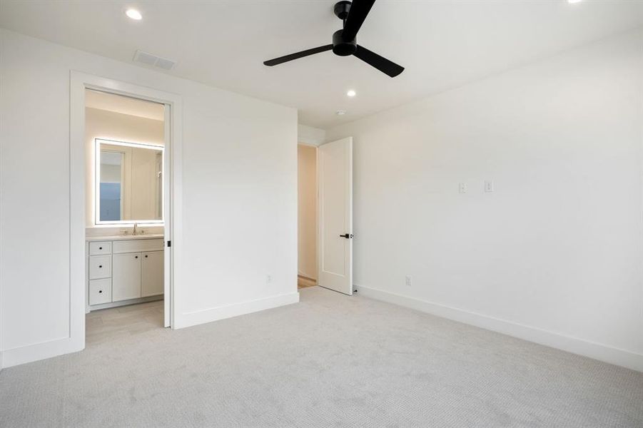 Unfurnished bedroom with light carpet, recessed lighting, ceiling fan, and connected bathroom Unfurnished bedroom with light carpet, recessed lighting, ceiling fan, and connected bathroom