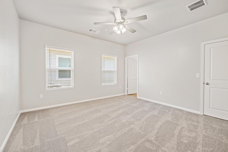 Spare room featuring light colored carpet and a ceiling fan Spare room featuring light colored carpet and a ceiling fan