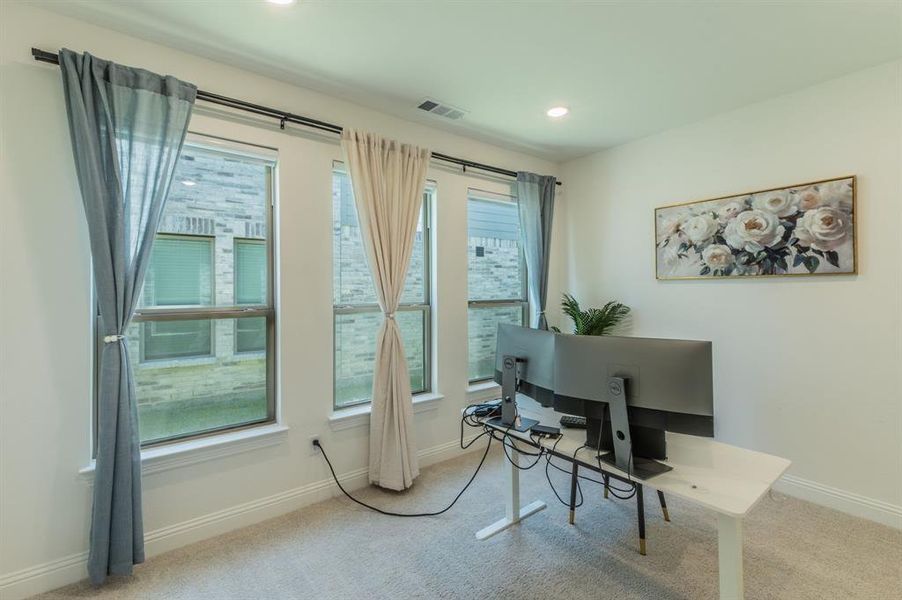 Room featuring three large windows with white trim, recessed lighting, and light gray carpet