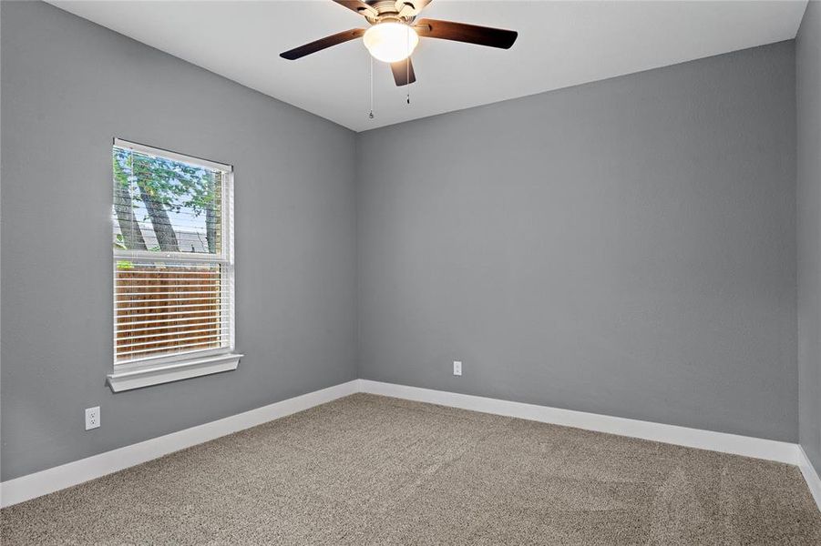 Empty room with carpet floors and a ceiling fan Empty room with carpet floors and a ceiling fan