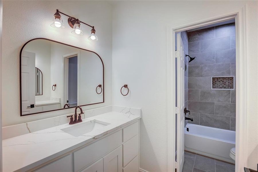 Bathroom featuring vanity, bathtub / shower combination, and tile patterned floors Bathroom featuring vanity, bathtub / shower combination, and tile patterned floors