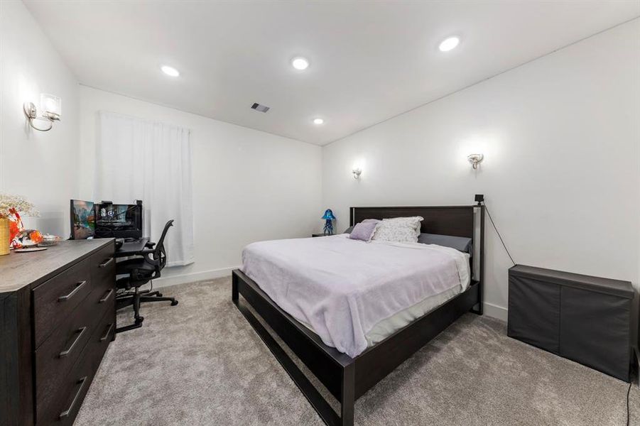 Originally designed as a media room, this space is currently utilized as a fourth bedroom. It features a spacious closet, plush carpeting, and recessed lighting, creating a cozy and inviting atmosphere.