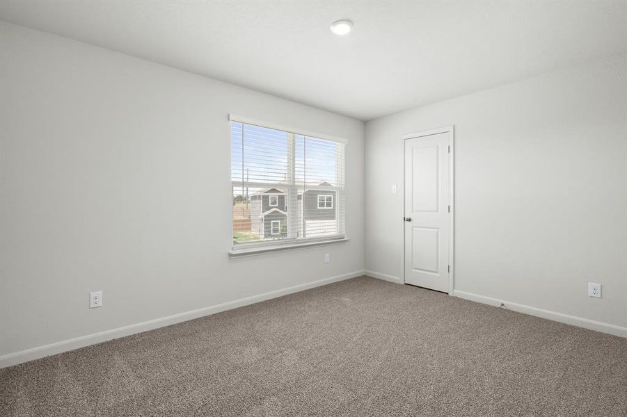 Carpeted spare room featuring baseboards