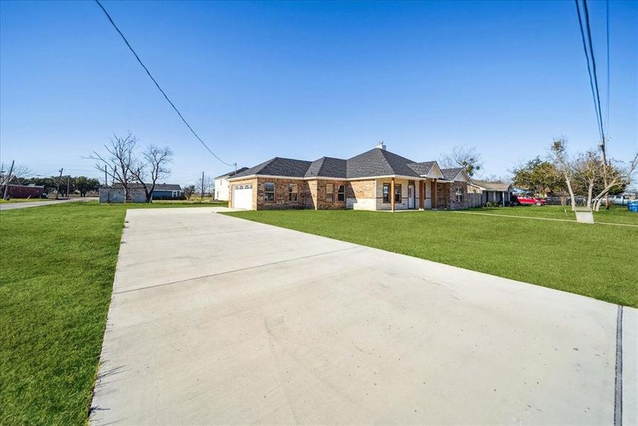 Single story home with a garage and a front lawn