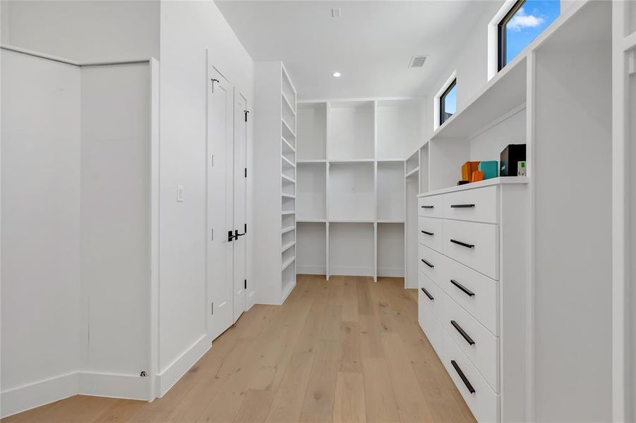 Walk in closet featuring light wood-style flooring Walk in closet featuring light wood-style flooring