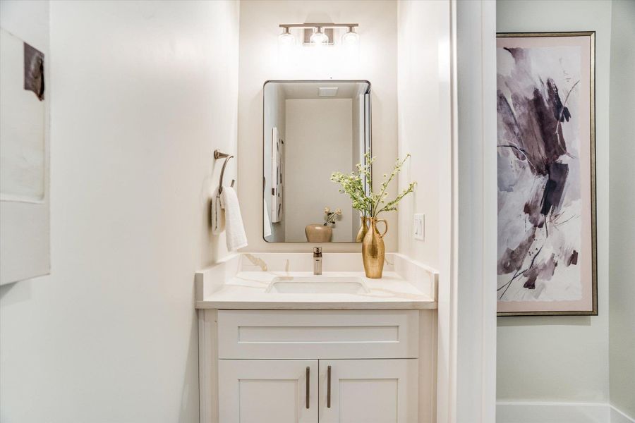 Modern vanity with a white countertop and a rectangular mirror, complemented by an overhead light fixture Modern vanity with a white countertop and a rectangular mirror, complemented by an overhead light fixture