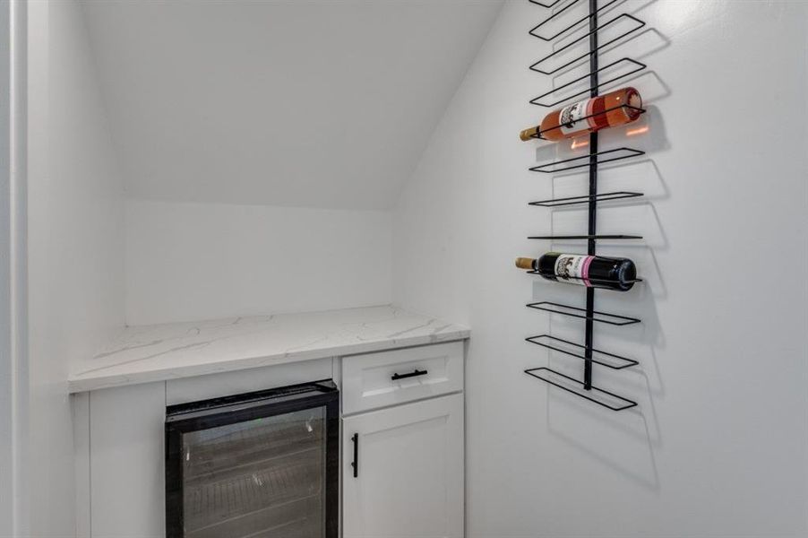 Custom-built wine room featuring a dedicated refrigerator, ideal for wine storage and entertaining. Custom-built wine room featuring a dedicated refrigerator, ideal for wine storage and entertaining.