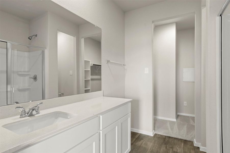 Bathroom featuring wood finished floors, a stall shower, and vanity