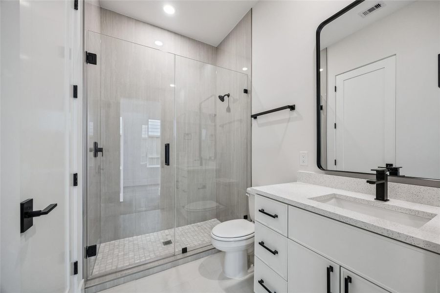 The secondary bath features quartz countertops, modern fixtures, and a glass-enclosed walk-in shower with full-height tile surround. Clean lines and a bright finish palette keep the space feeling cohesive with the rest of the home’s contemporary design. The secondary bath features quartz countertops, modern fixtures, and a glass-enclosed walk-in shower with full-height tile surround. Clean lines and a bright finish palette keep the space feeling cohesive with the rest of the home’s contemporary design.
