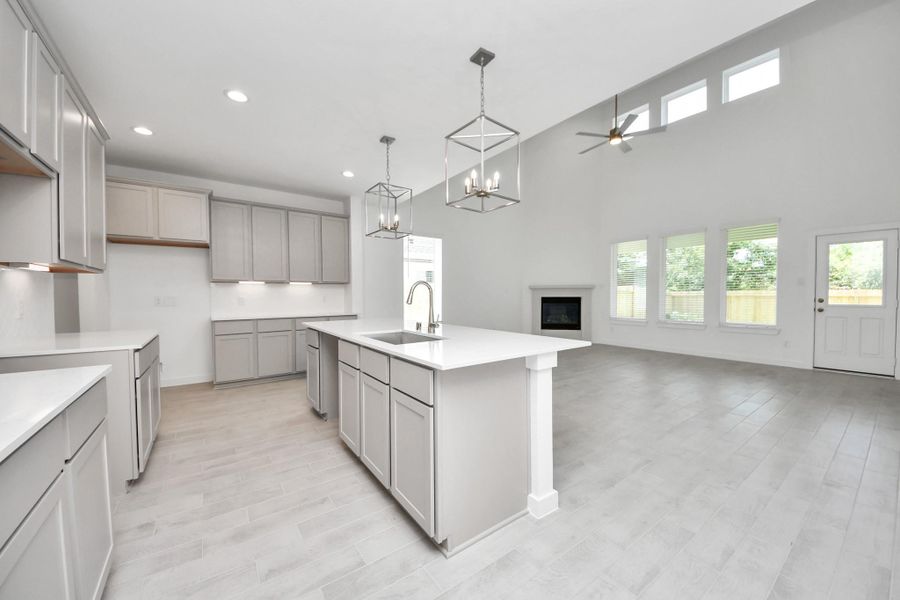 This kitchen is truly a chef's dream! This haven Boasts high ceilings, recessed & pendant lighting, stained wood cabinets, granite countertops, stainless steel appliances, a modern tile backsplash.  All of this overlooks your expansive family room, creating a perfect space for culinary delights and family gatherings. Sample photo of completed home with similar floor plan. Actual colors and selections may vary.