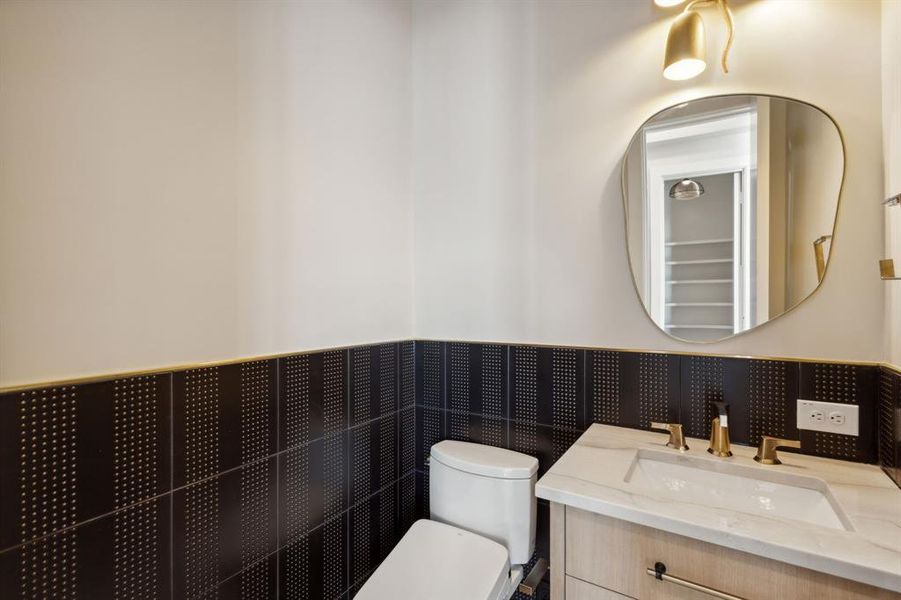 Bathroom with toilet, wainscoting, and vanity