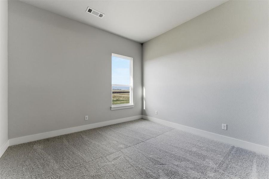 Carpeted spare room with baseboards