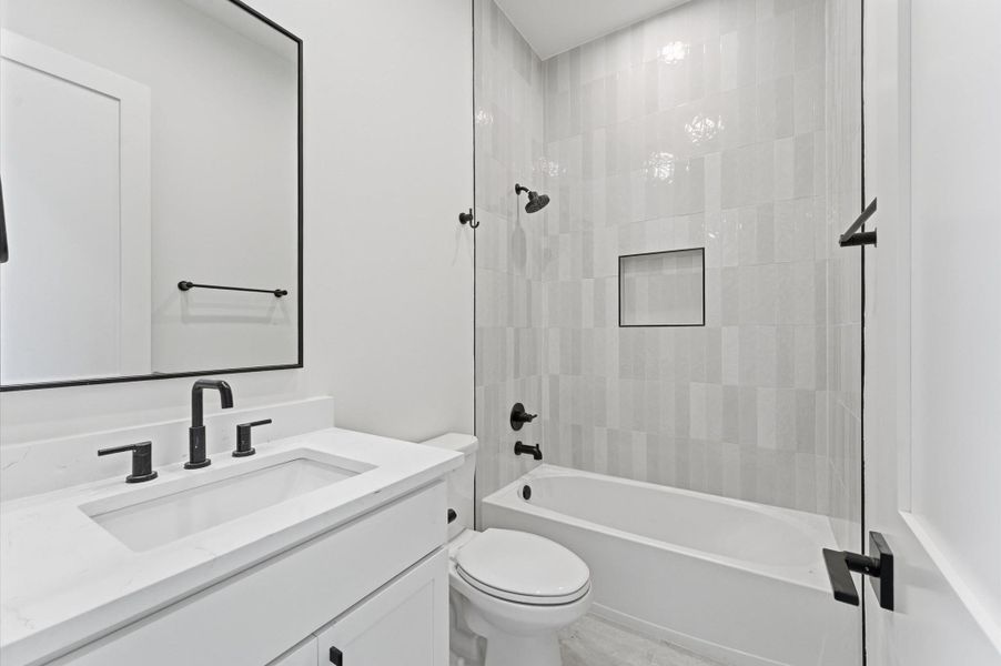 Secondary bathroom with quartz countertops and tub/shower combo.