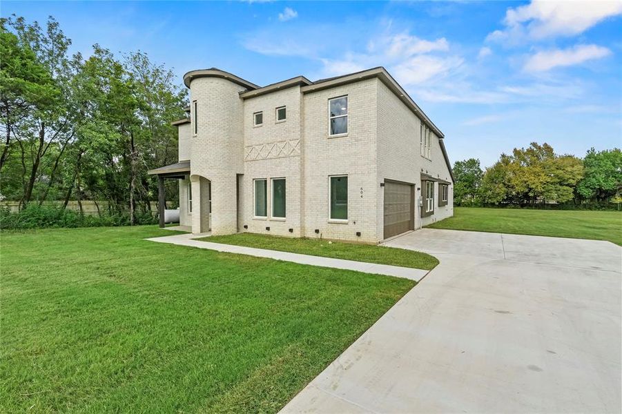 Back of property featuring brick siding, a yard, driveway, an attached garage, and crawl space Back of property featuring brick siding, a yard, driveway, an attached garage, and crawl space