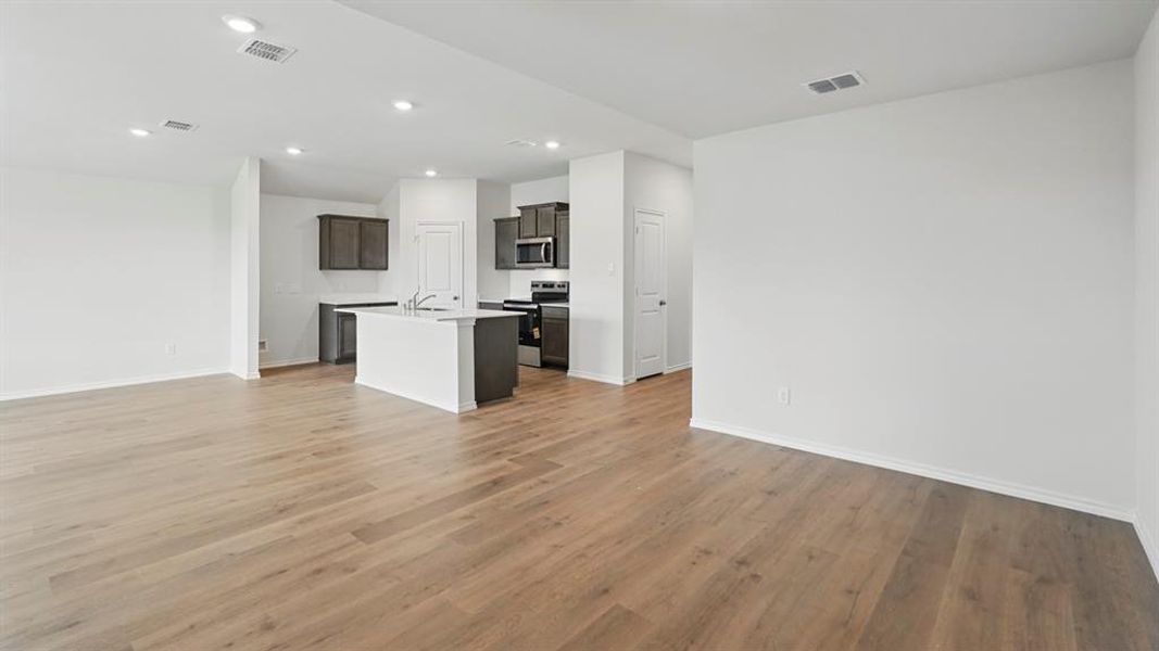 Spacious interior featuring wood-finish flooring, white walls, and recessed lighting