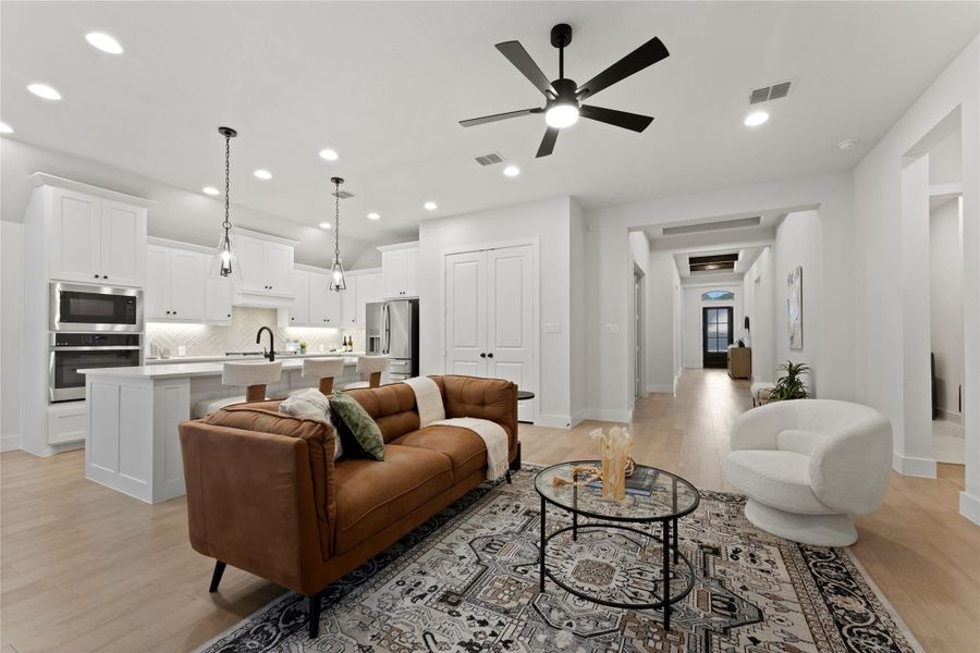 Open-concept living space featuring light wood-finish flooring and recessed lighting