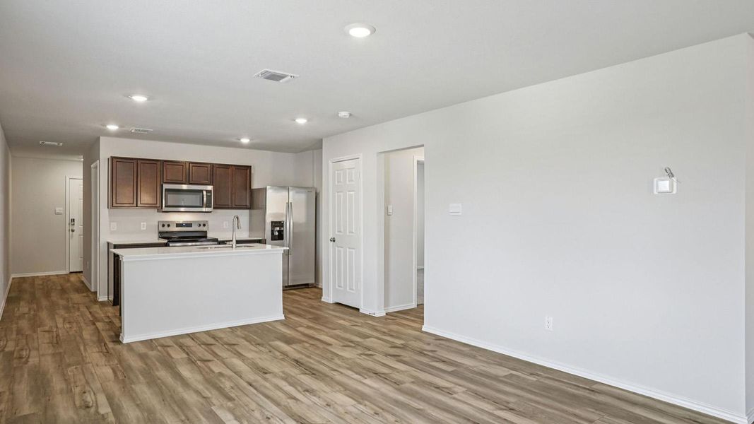 Kitchen with light countertops, a center island with sink, stainless steel appliances, light wood-style flooring, and recessed lighting