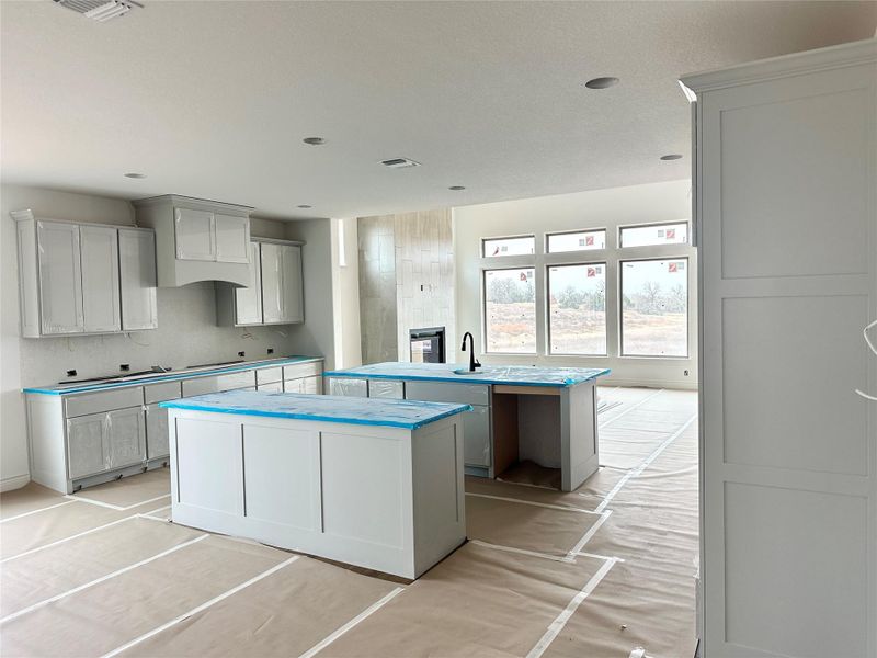 Kitchen with a kitchen island with sink and gray cabinetry