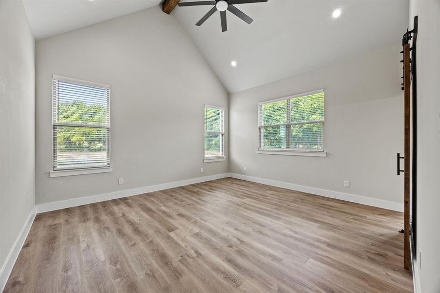 Spare room with high vaulted ceiling, healthy amount of natural light, beamed ceiling, light wood-type flooring, and recessed lighting Spare room with high vaulted ceiling, healthy amount of natural light, beamed ceiling, light wood-type flooring, and recessed lighting