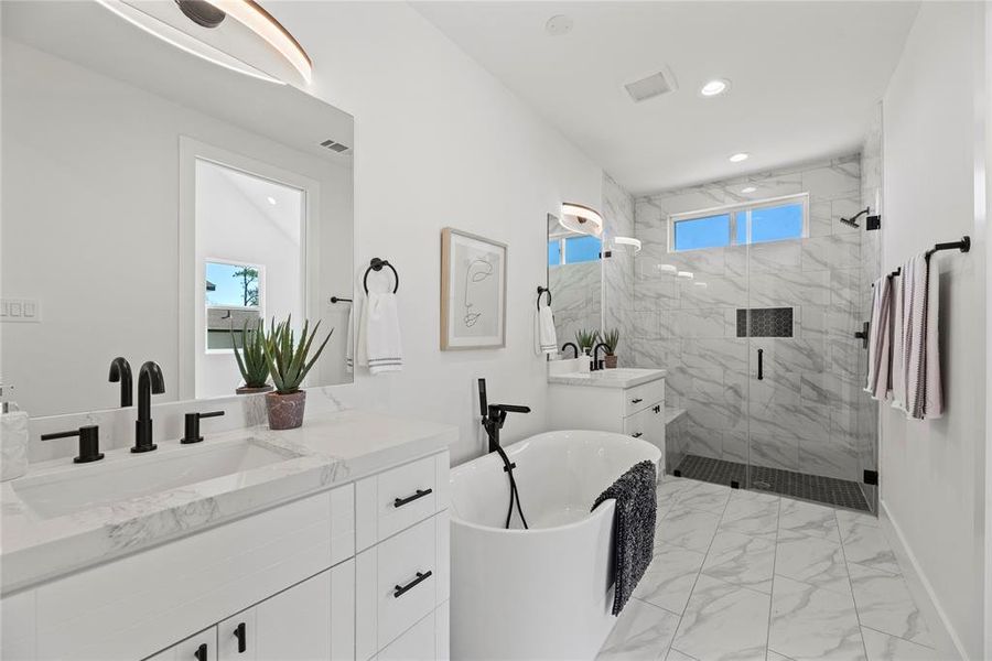 The primary bathroom features double vanities, a deep, stand alone tub, and roomy shower.