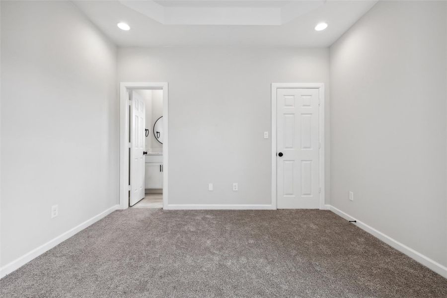 Unfurnished bedroom featuring carpet, recessed lighting, baseboards, and ensuite bath Unfurnished bedroom featuring carpet, recessed lighting, baseboards, and ensuite bath