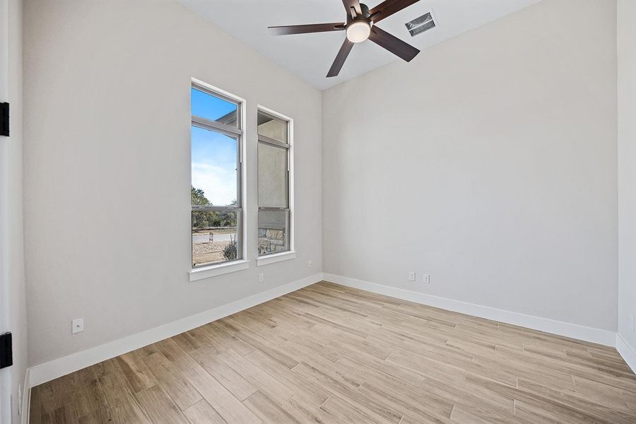 Spare room featuring light wood finished floors and ceiling fan Spare room featuring light wood finished floors and ceiling fan