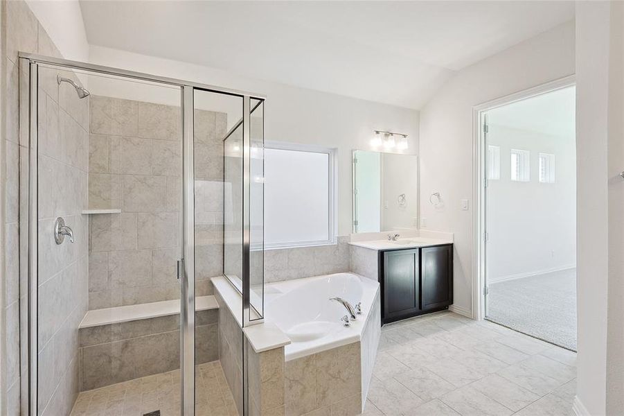 Bathroom with lofted ceiling, separate shower and tub, and vanity