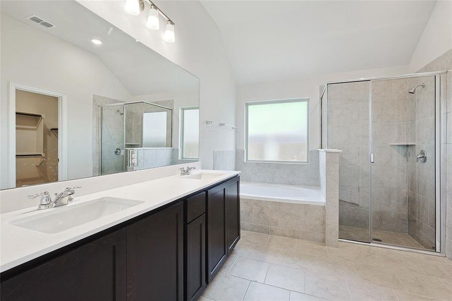 Bathroom with lofted ceiling, tile patterned floors, plus walk in shower, and dual bowl vanity