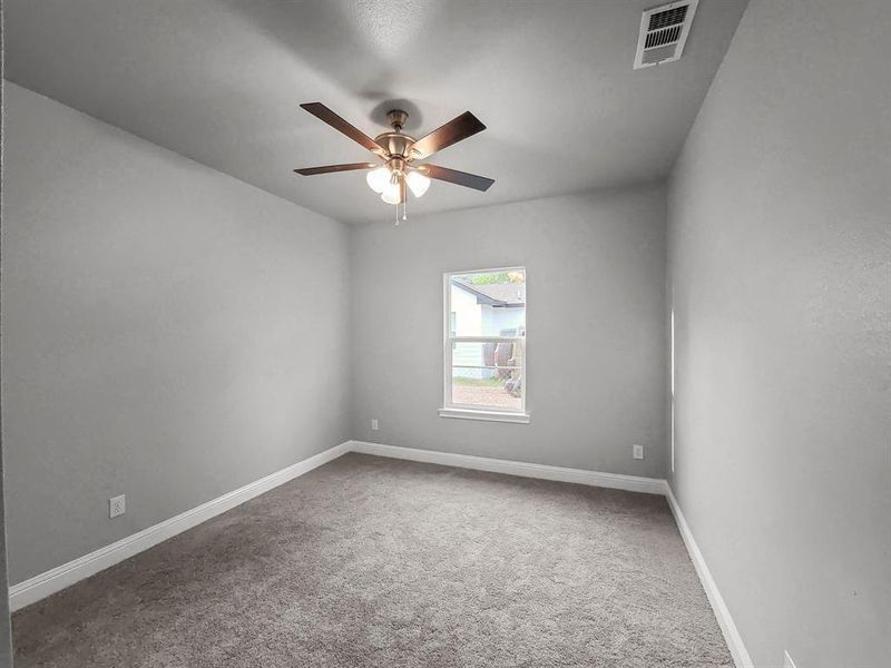 Carpeted spare room featuring ceiling fan and baseboards Carpeted spare room featuring ceiling fan and baseboards