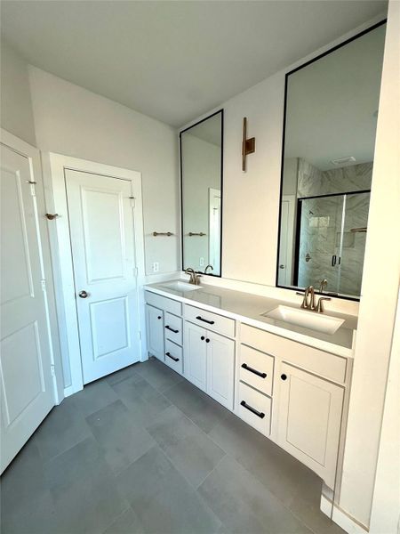 Impeccable style and selections in this bathroom showcased by the double mirrors, vertical gold light fixture, and abundant cabinetry. Impeccable style and selections in this bathroom showcased by the double mirrors, vertical gold light fixture, and abundant cabinetry.