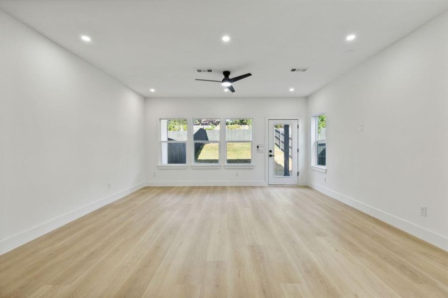 Unfurnished living room with light hardwood / wood-style floors and ceiling fan