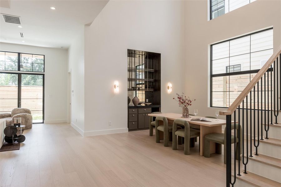 The open dining area sits beneath a dramatic two story ceiling, with custom built in wine storage and a wet bar creating a natural destination for entertaining. The open dining area sits beneath a dramatic two story ceiling, with custom built in wine storage and a wet bar creating a natural destination for entertaining.
