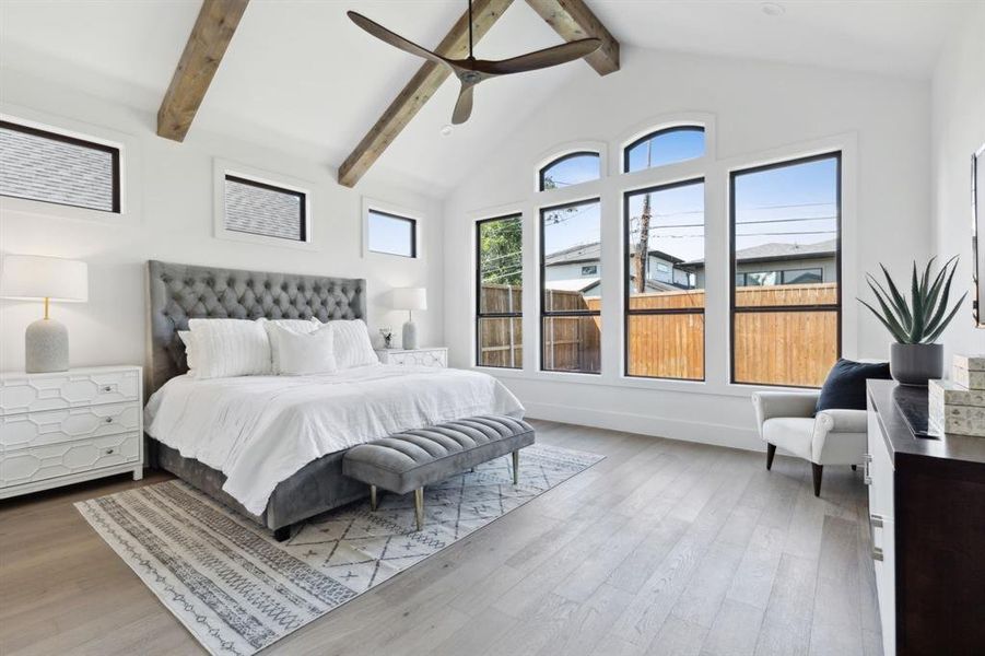 Bedroom with ceiling fan, hardwood / wood-style floors, high vaulted ceiling, and beam ceiling