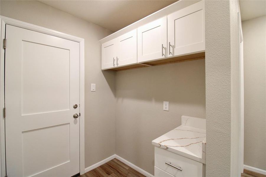 Laundry area with light wood-style floors and baseboards