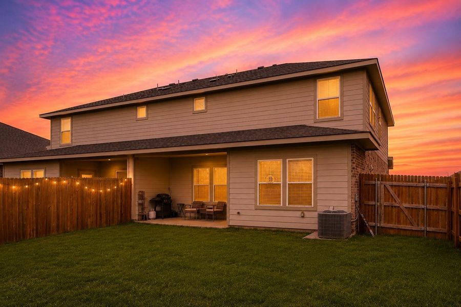 Rear exterior featuring a covered patio, brick and siding facade, and a private fenced yard with a gate Rear exterior featuring a covered patio, brick and siding facade, and a private fenced yard with a gate