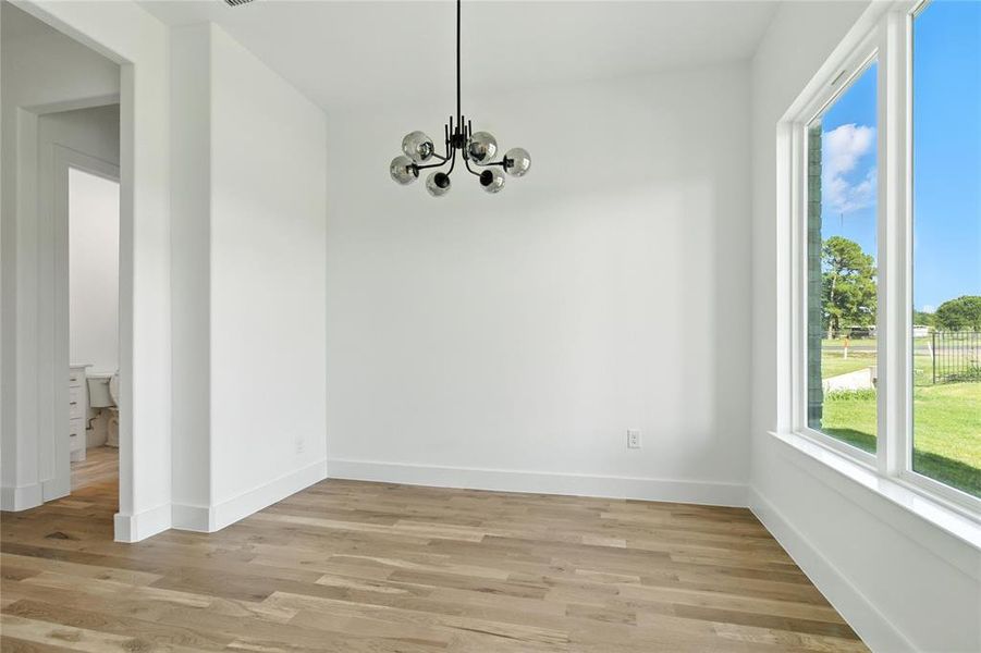 Unfurnished dining area featuring light wood-style flooring and a chandelier