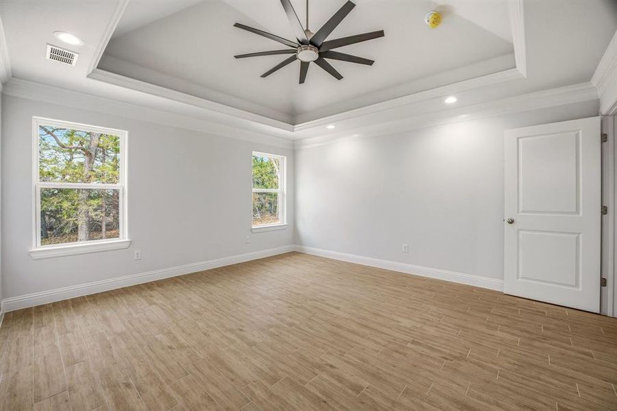 Empty room featuring wood tiled floors, ceiling fan, recessed lighting, and crown molding Empty room featuring wood tiled floors, ceiling fan, recessed lighting, and crown molding